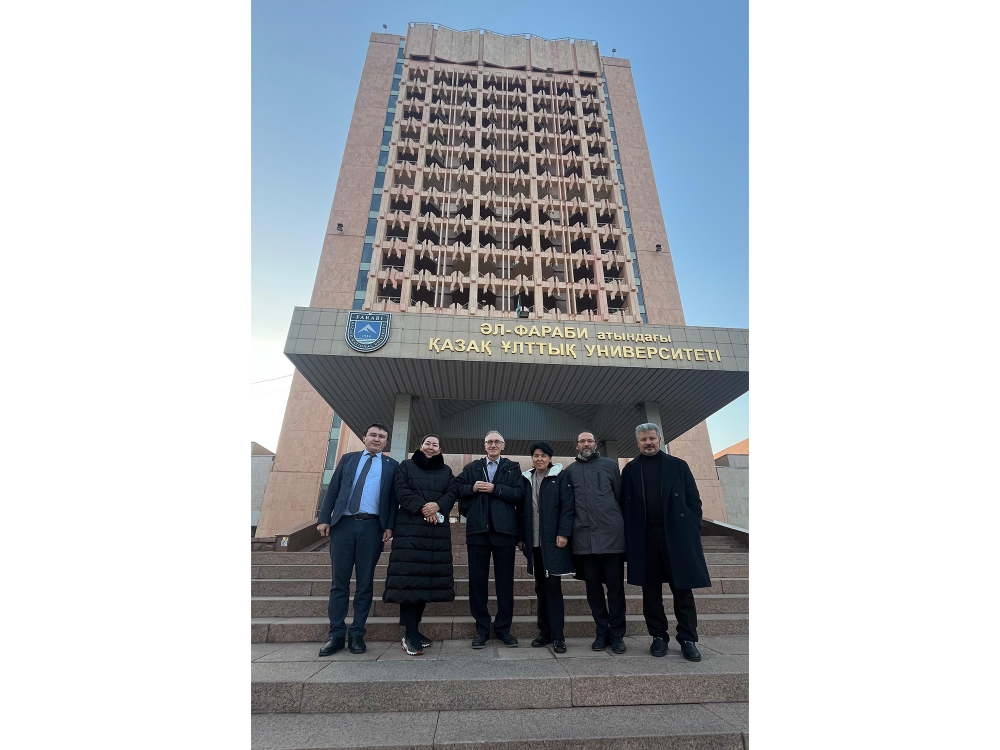 Six people standing in front of a tall building with Cyrillic writing