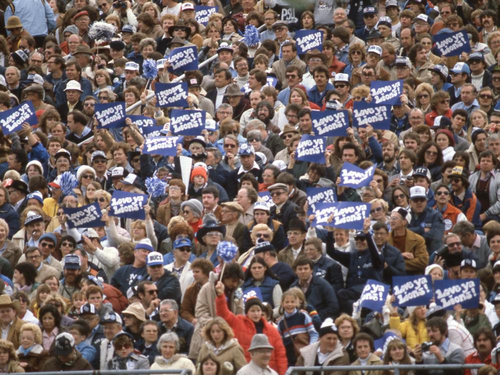 A crowd of Penn State football fans holding signs that read "Love Ya Lions"