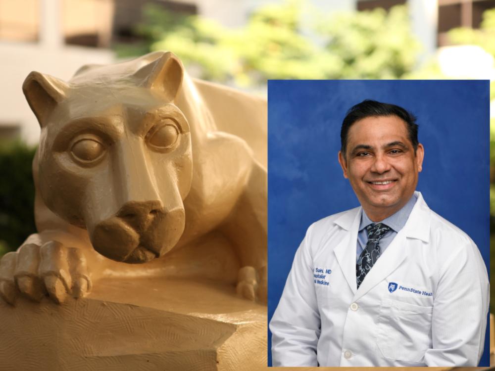 A professional headshot of Dr. Ajay Saini wearing a white medical coat is superimposed over a larger image of a Nittany Lion statue.