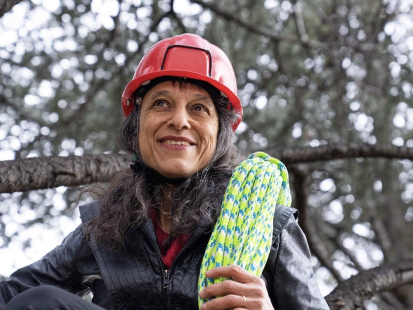 Ecologist Nalini Nadkarni wears a helmet and holds a rope for climbing trees and exploring tree ecology