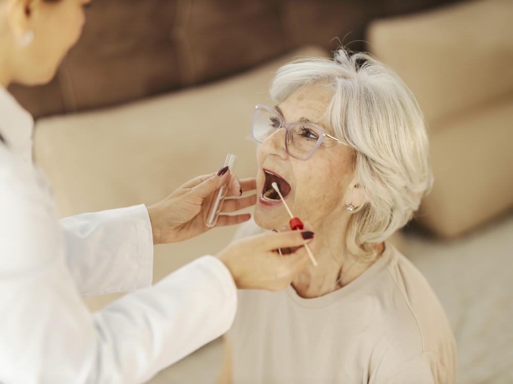 A medical professional collecting a cheek swab from an older person