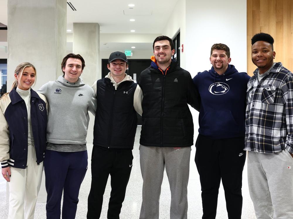 Six students standing and smiling