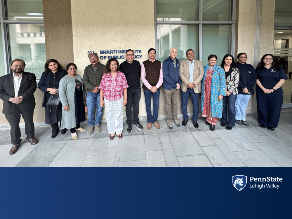 faculty members stand in front of an academic building 