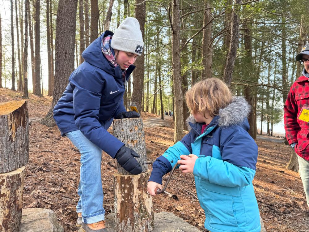 Penn State student helps festivalgoer tap tree stump