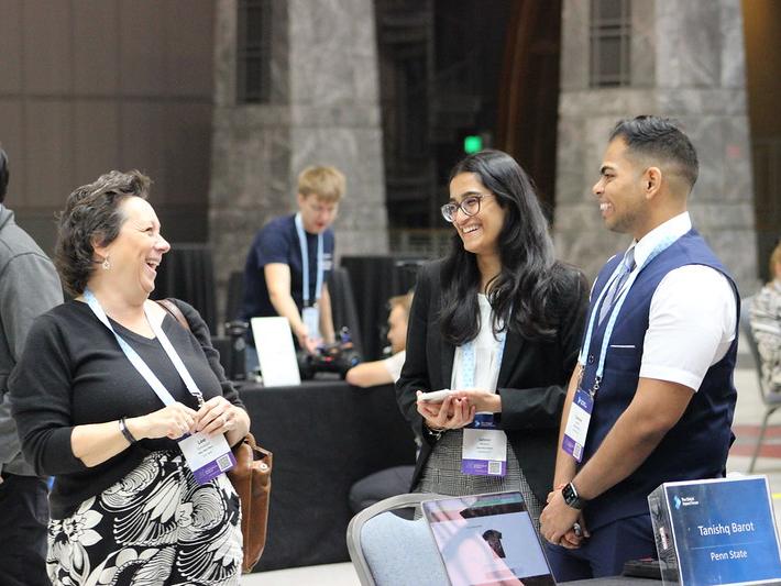 People talking and laughing at a business conference.
