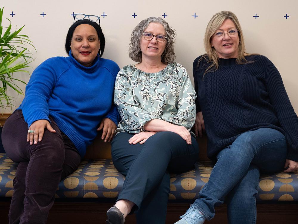 Three women sitting on a bench 