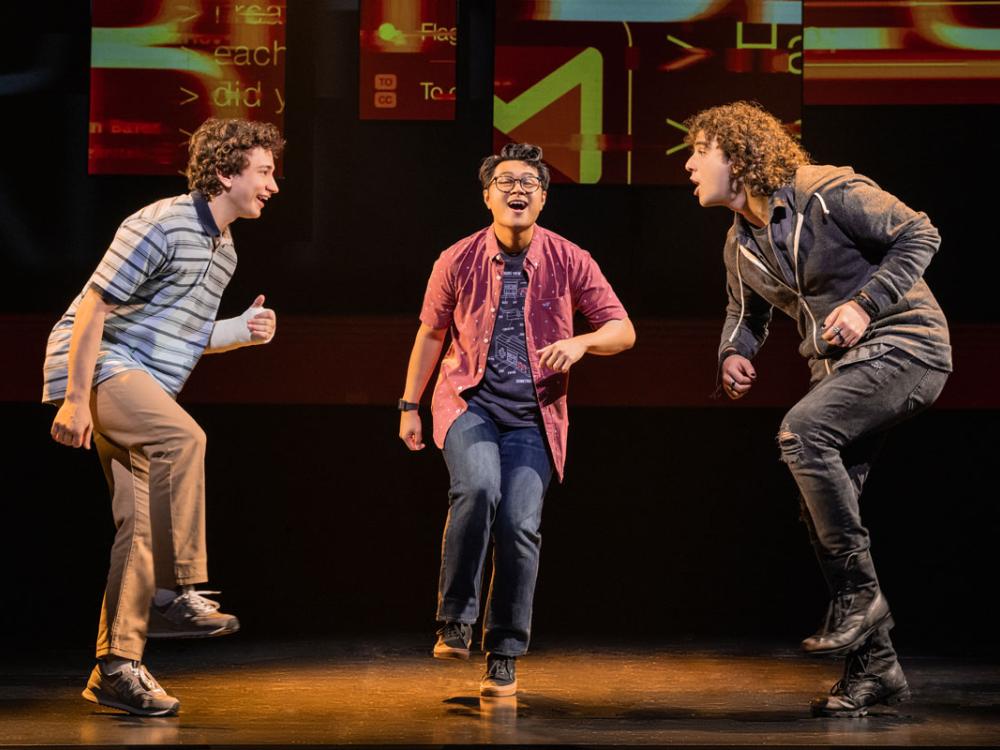 Three teen-age boys dance in unison in a semi-circle.