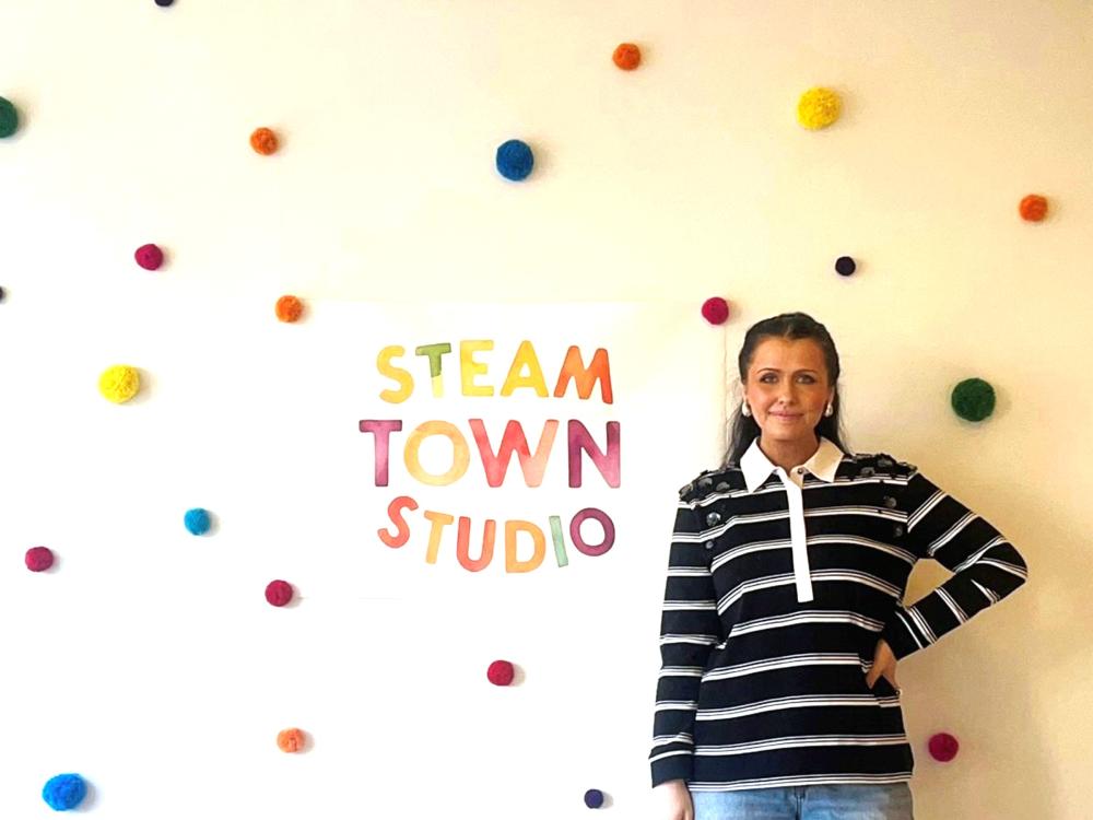 Emily Pinto stands in front of her Steam Town Studio business