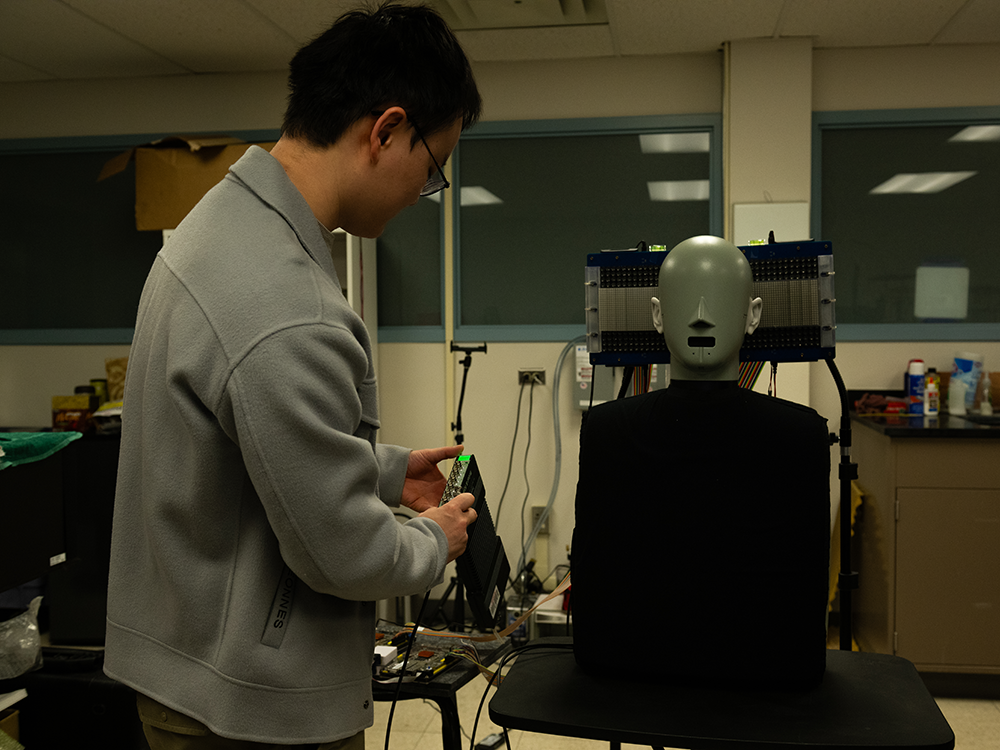 A researcher manipulates a dummy in a lab.