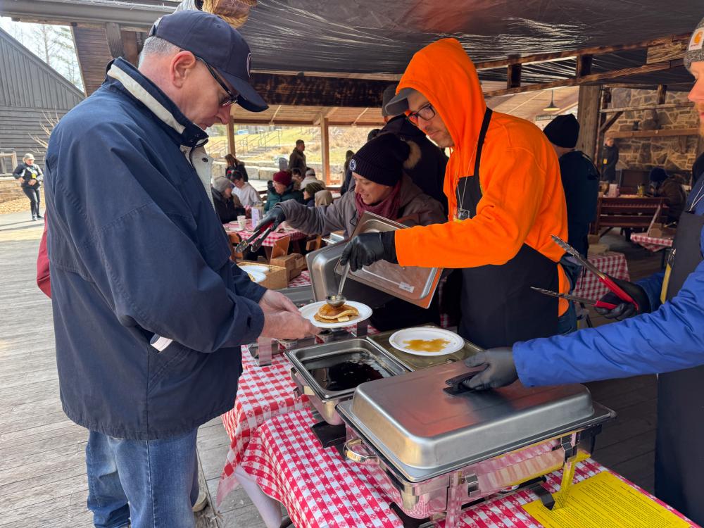 Volunteer serves visitor pancake