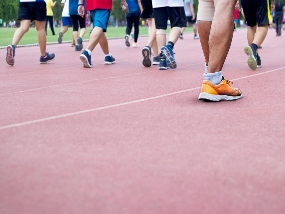 A group of people all walking on a track