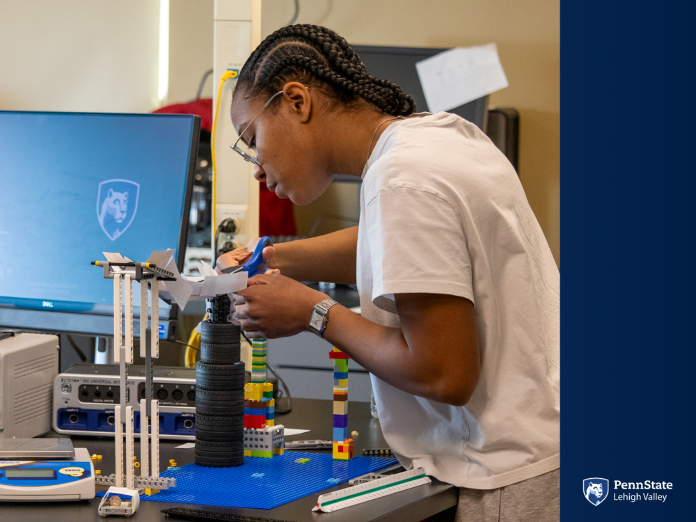 a female students works on her engineering marble run project