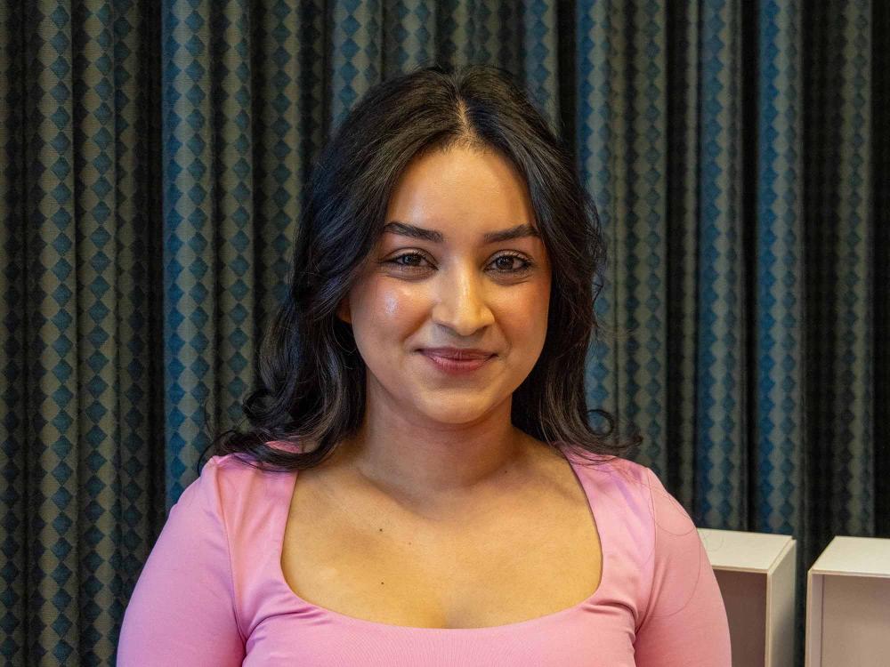 Tapashya Ghimirey smiles on stage at Penn State Greater Allegheny.