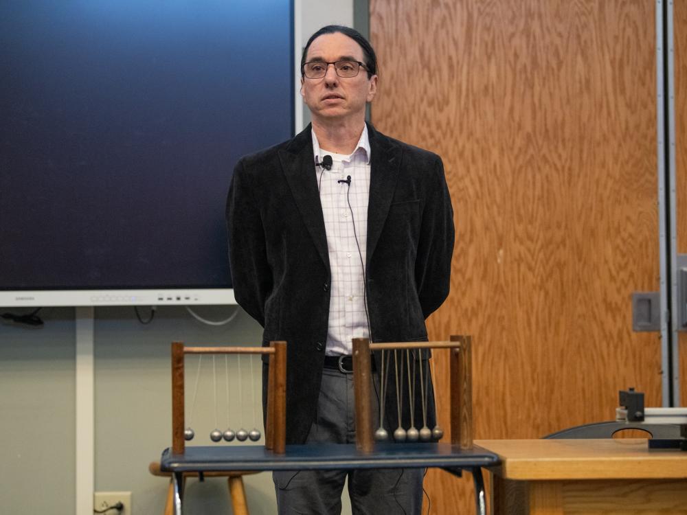 Person standing in front of a physics experiment during the Ashtekar Frontiers of Science lecture
