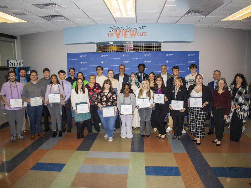 group of new Tri-Alpha members pose for a photo holding their membership certificates