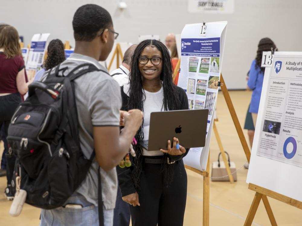 Students presenting research in poster session