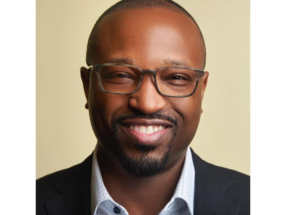 headshot of smiling person wearing glasses