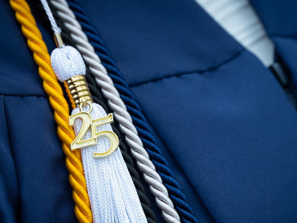 Closeup of a graduation tassel with a gold 25 attached