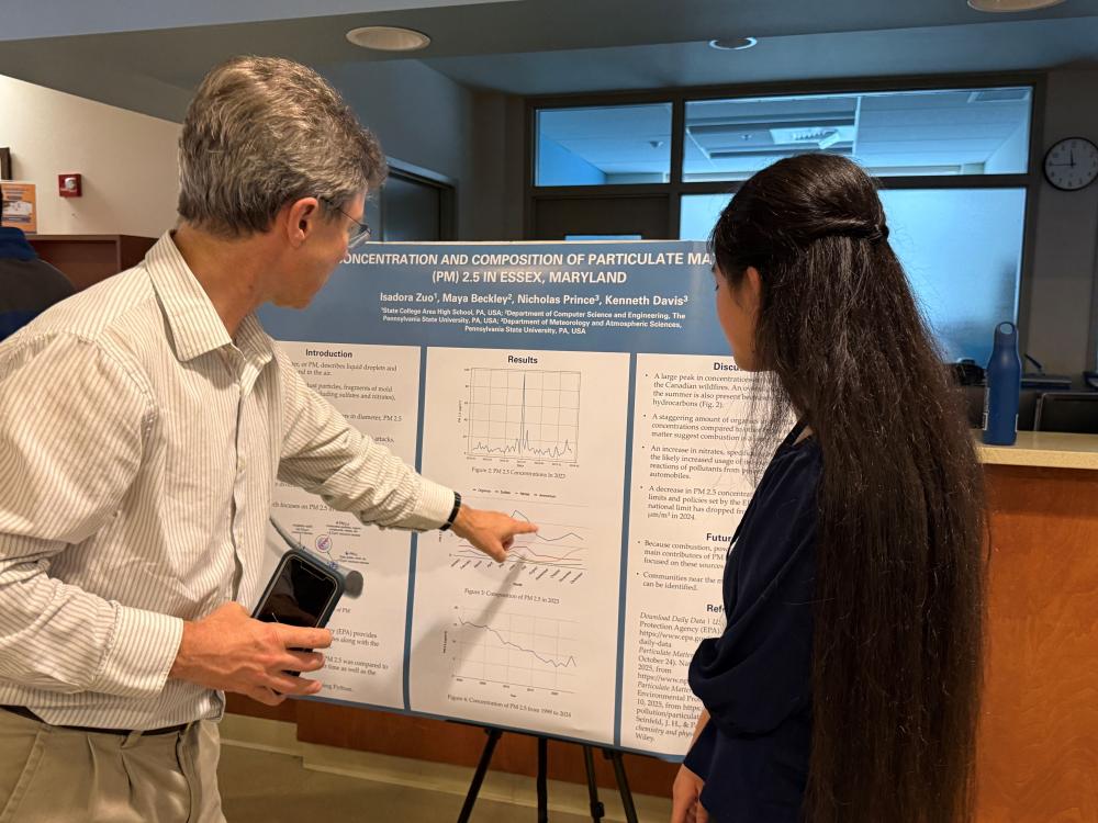 A professor comments on a student's research poster