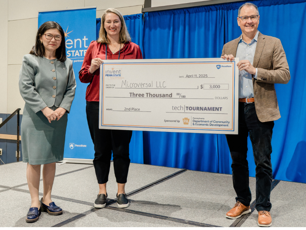 Three individuals pose with over-sized check for $3,000