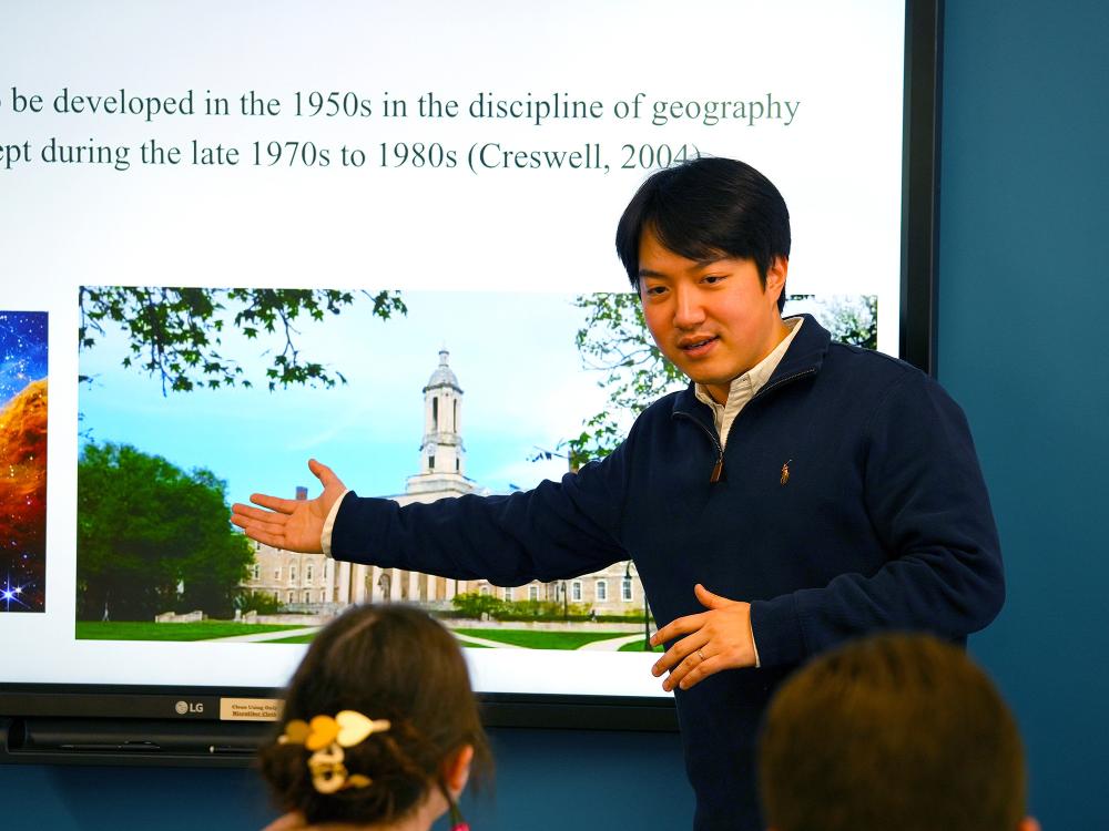 person pointing to projector screen while giving a lecture