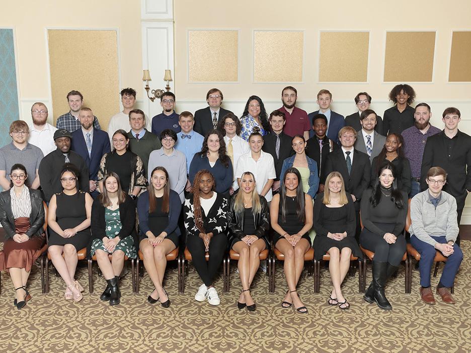 A large group of students posing indoors in several rows.