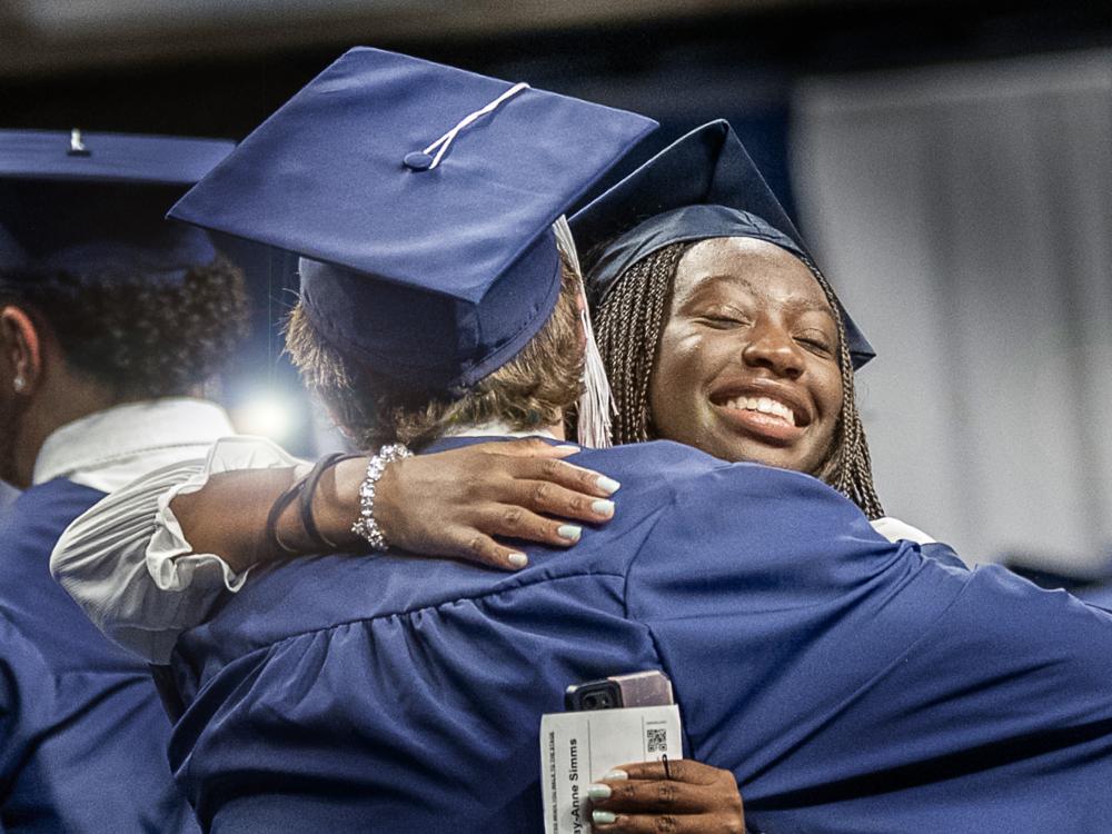 graduates hug