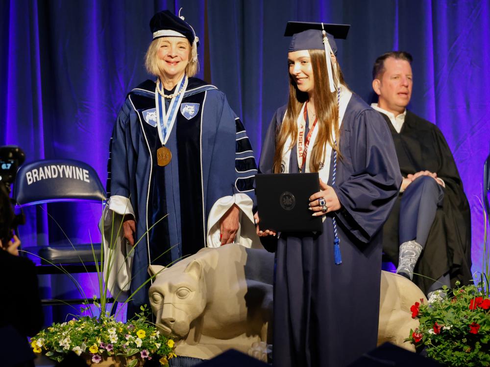 A female student receives her diploma at Brandywine's commencement ceremony.