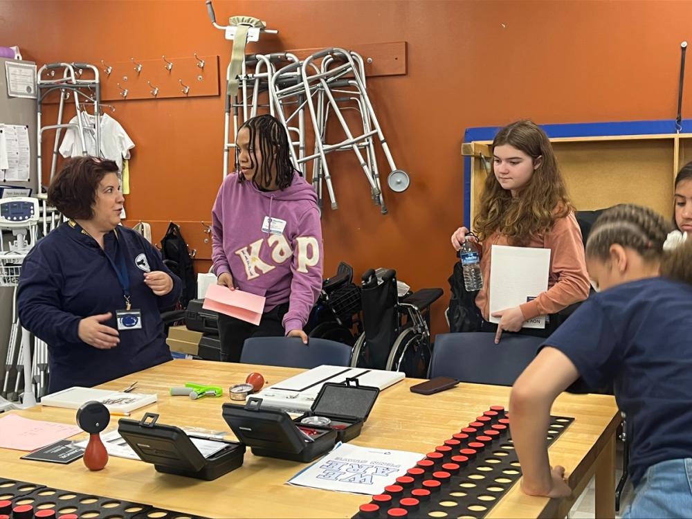 An instructor works in an occupational therapy classroom with students