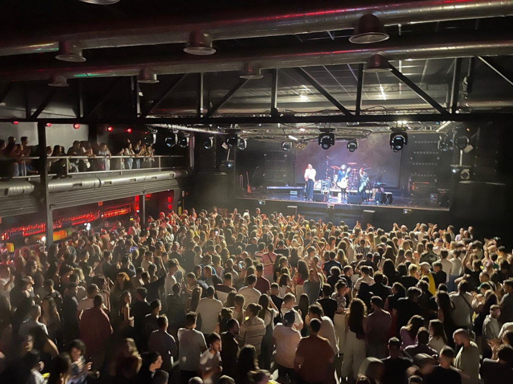View of a band playing on a stage at a concert with an audience watching