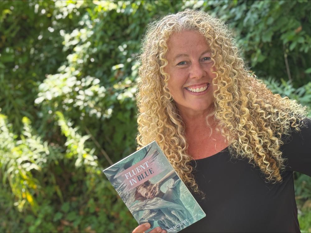 Penn State Altoona Professor Erin Murphy holding a copy of her latest book Fluent in Blue