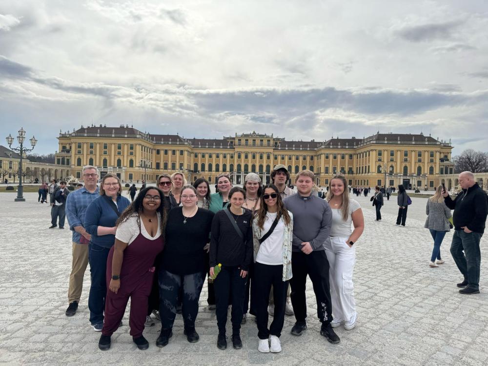A group of students stand in the plaza of a palace in Vienna