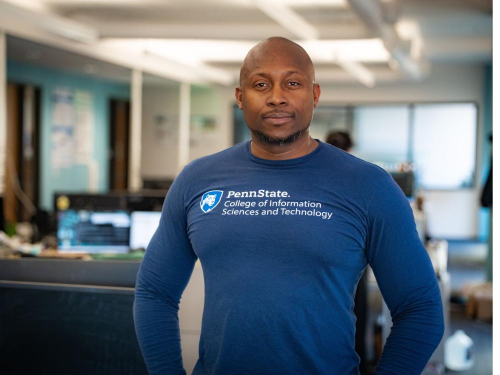 unsmiling bald person in blue long-sleeve college shirt