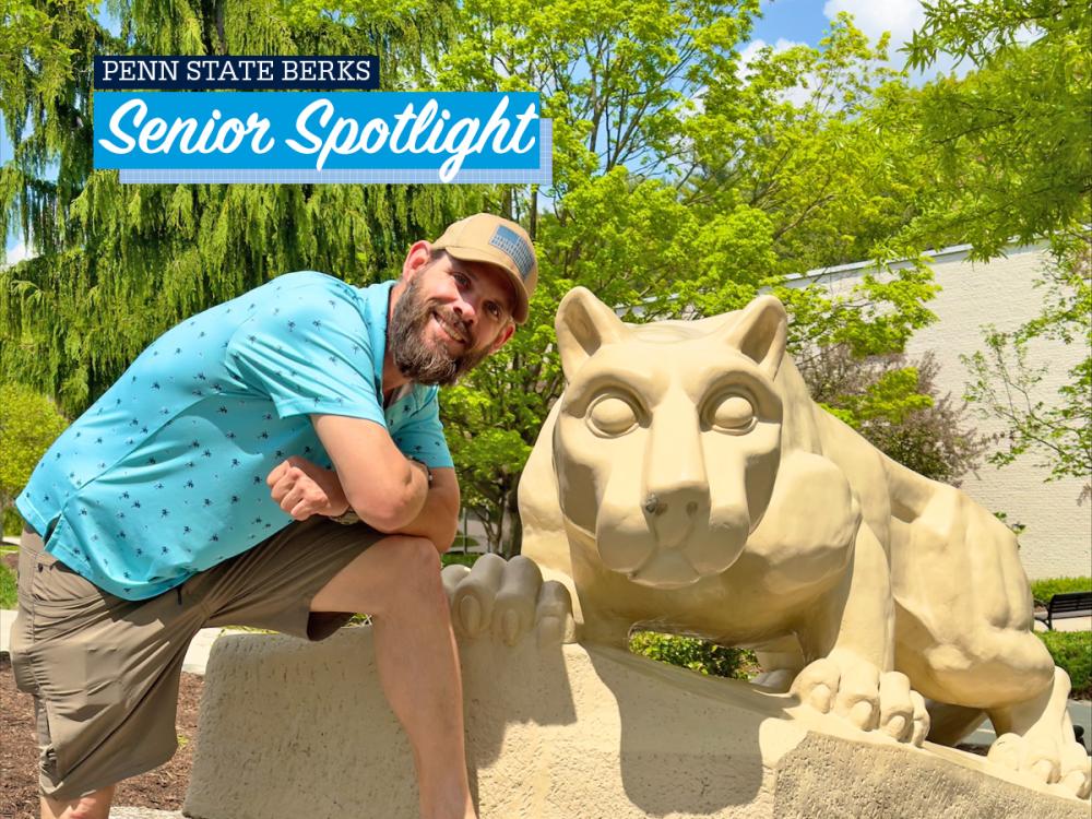 Kevin Michaels smiling when posing next to Lion Shrine