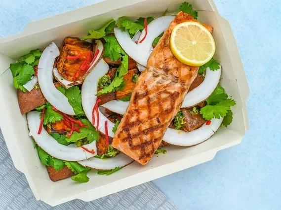 a baking dish with salmon and veggies