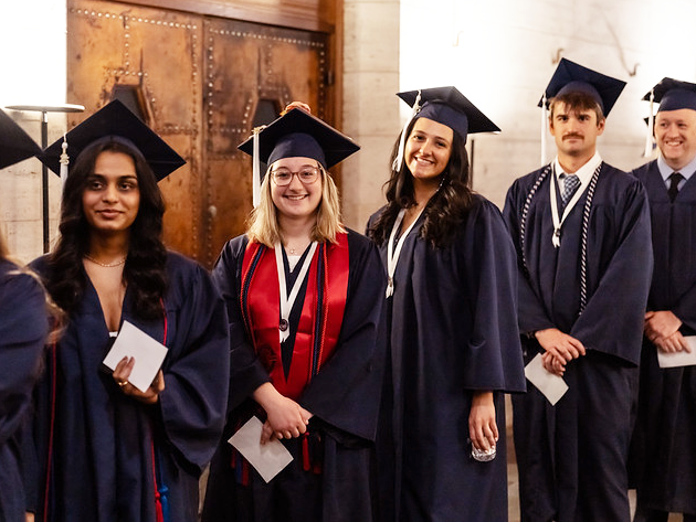 group of grads in cap and gown smiling