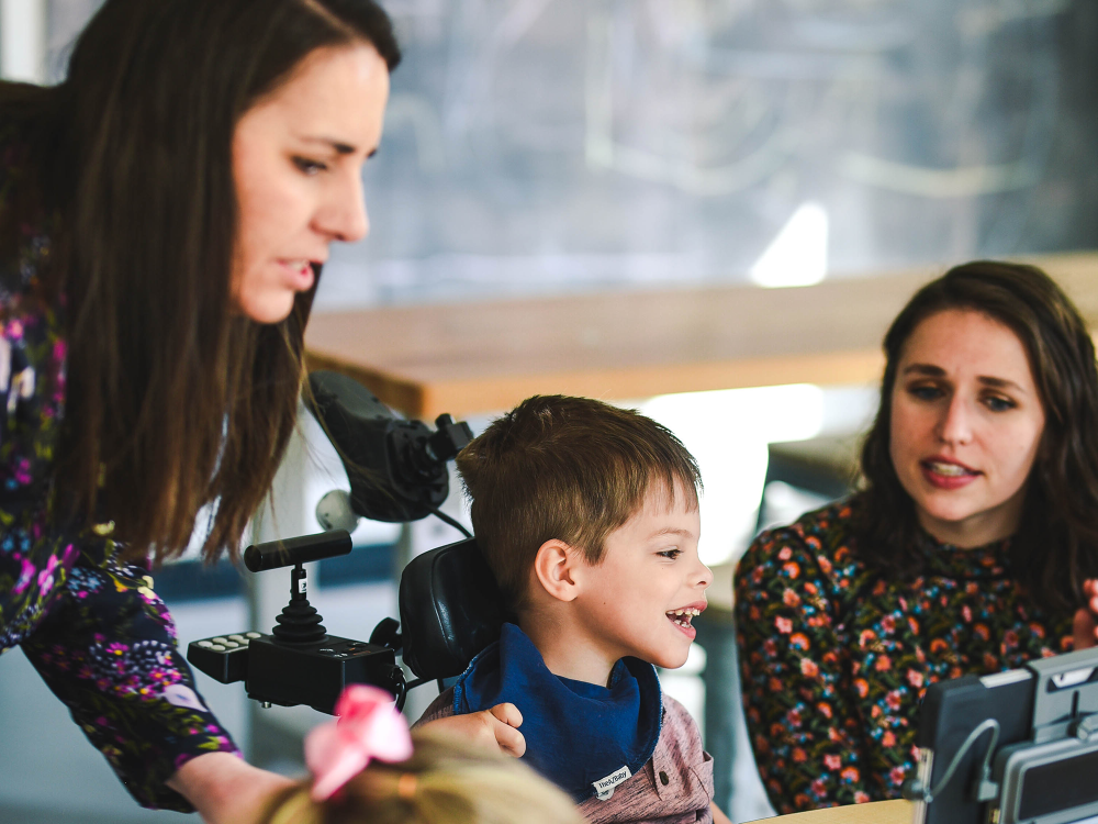 Two instructors working with a child with cerebral palsy