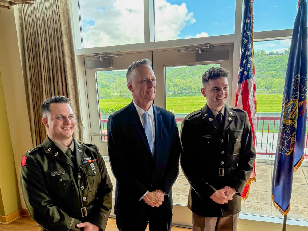 Three people pose for a photograph in a sunny room