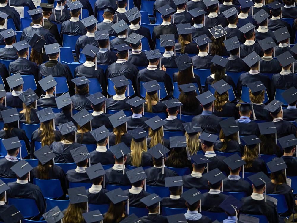 A photo of a sea of blue caps during a commencement ceremony.