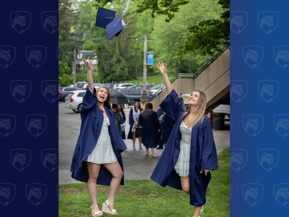 Two women throwing graduation caps in the air