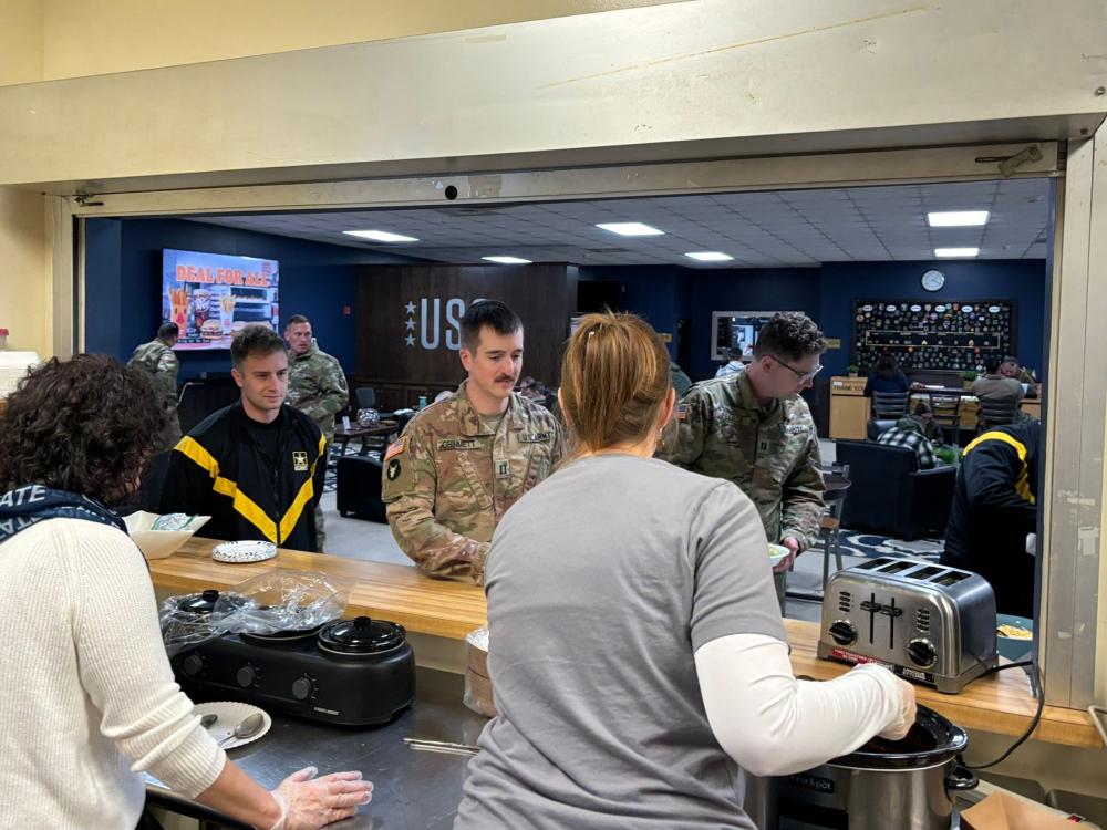 two women serve soldiers lunch at a counter