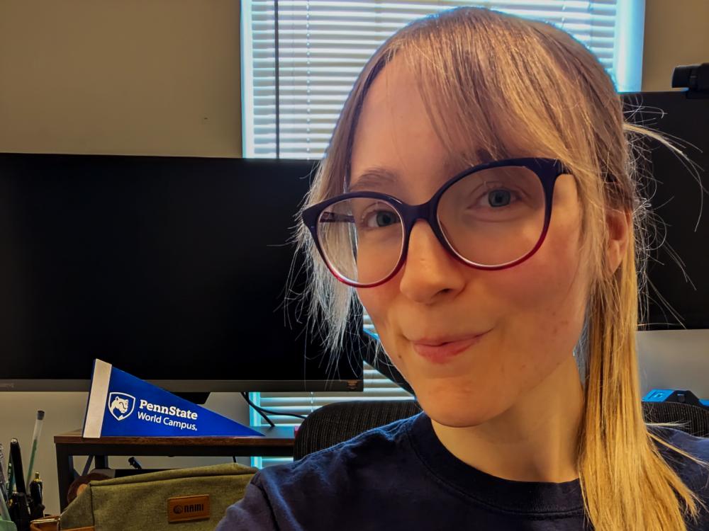 Penn State World Campus student Jessie Wolfen poses against the backdrop of her home computer. 