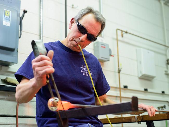 Man working on blowing glass in studio