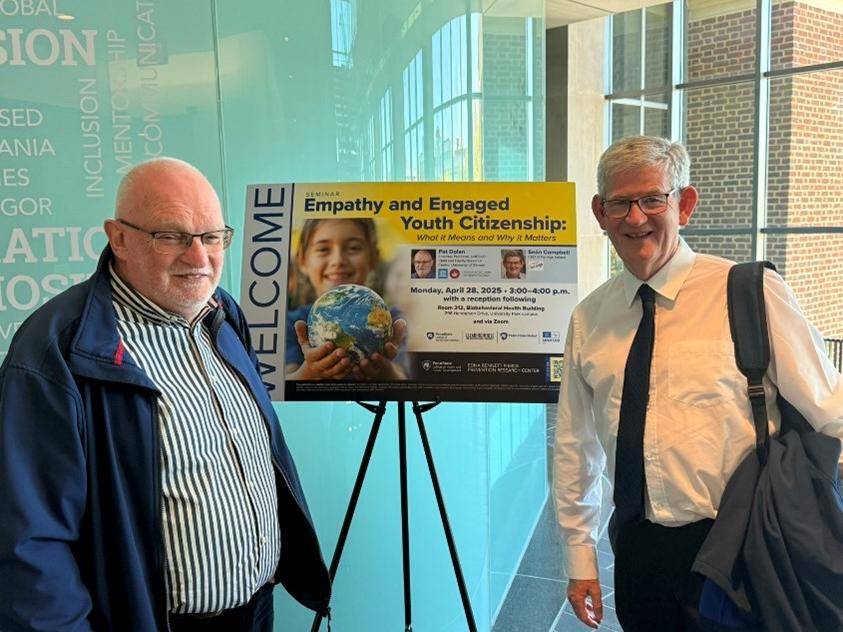 Two men standing on either side of a presentation poster