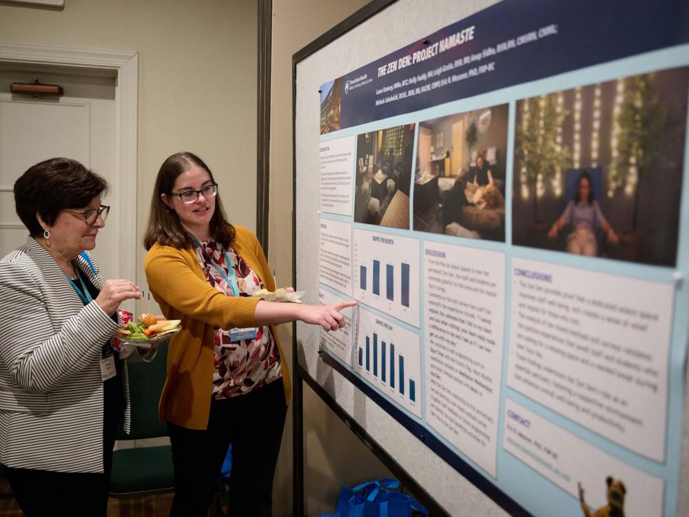 Symposium attendee presenting research at the event's poster presentation.