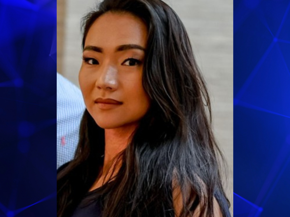 A professional photo of a woman against a blue background.