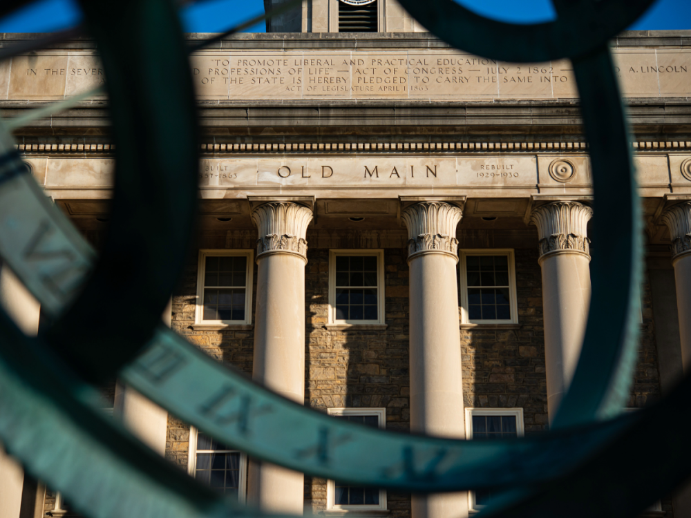 A view of Old Main building through a metal sculpture.