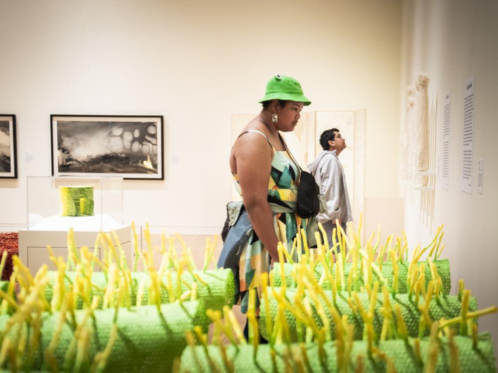 Two people behind a green and yellow sculpture