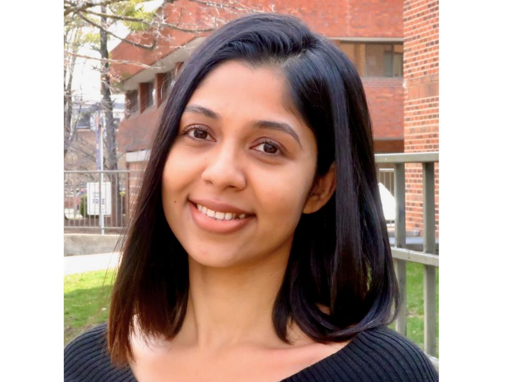 headshot of smiling person with shoulder-length dark hair