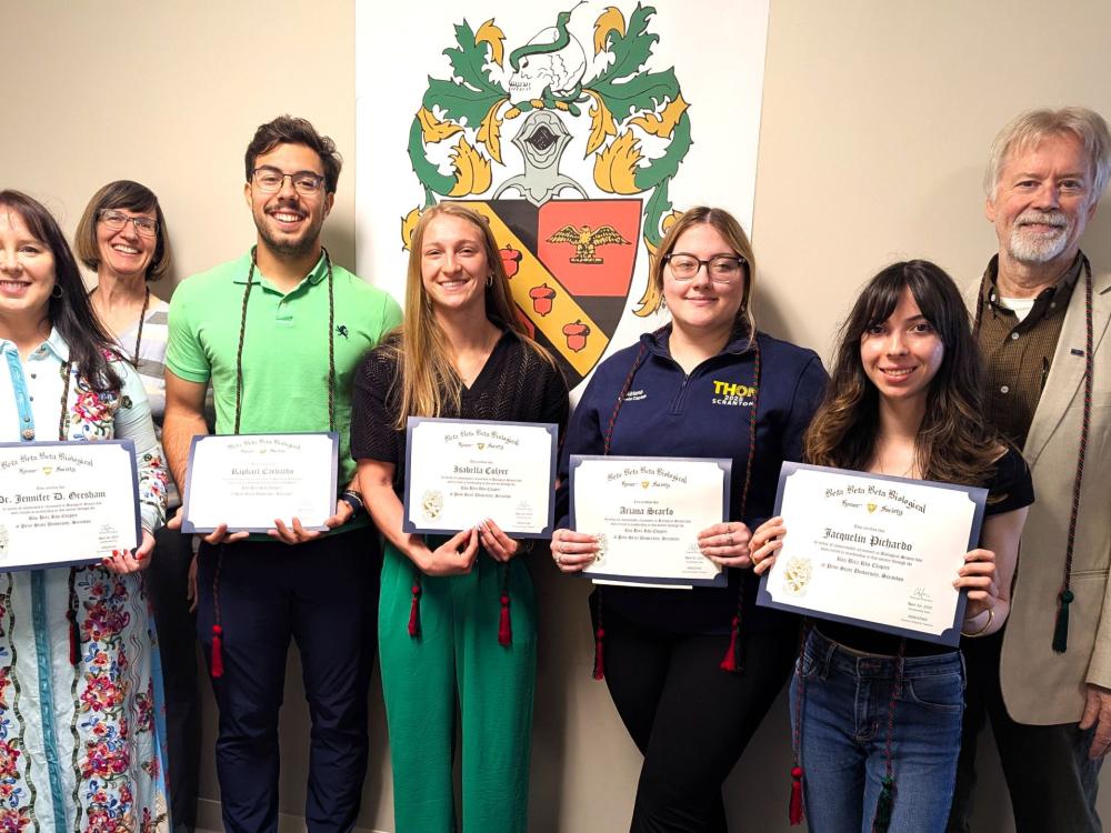 new beta beta beta inductees pose for a photo holding their membership certificates